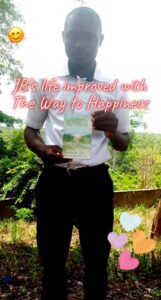 young man holds the way to happiness booklet in Siera Leone 